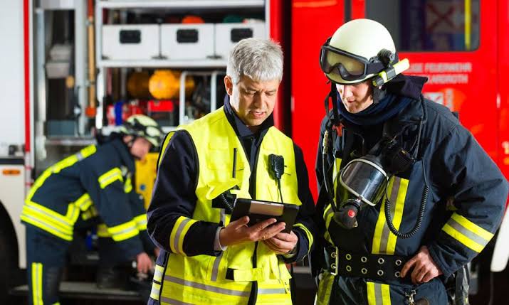 Fire officers reviewing building life-safety information on a tablet at the apparatus bay