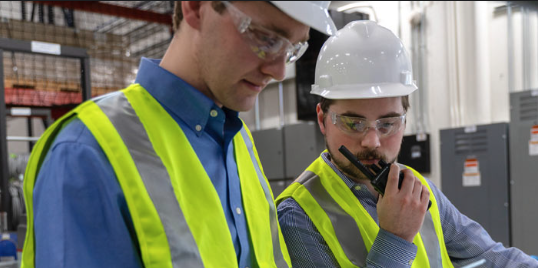 Two Maritech engineers walking a commercial install with two-way radios